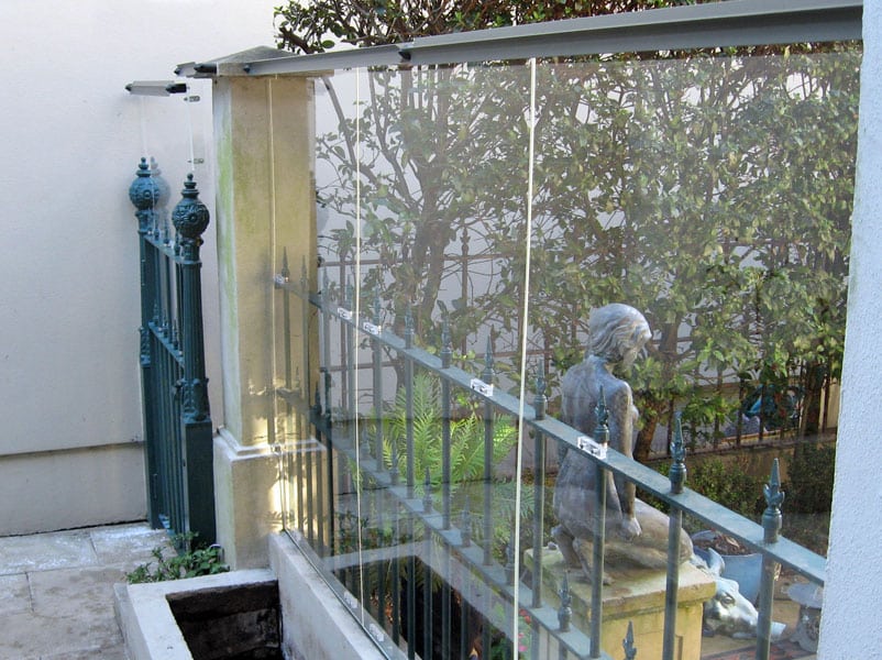 Clear acrylic was used to raise the height of this fence while still allowing natural light into the courtyard.