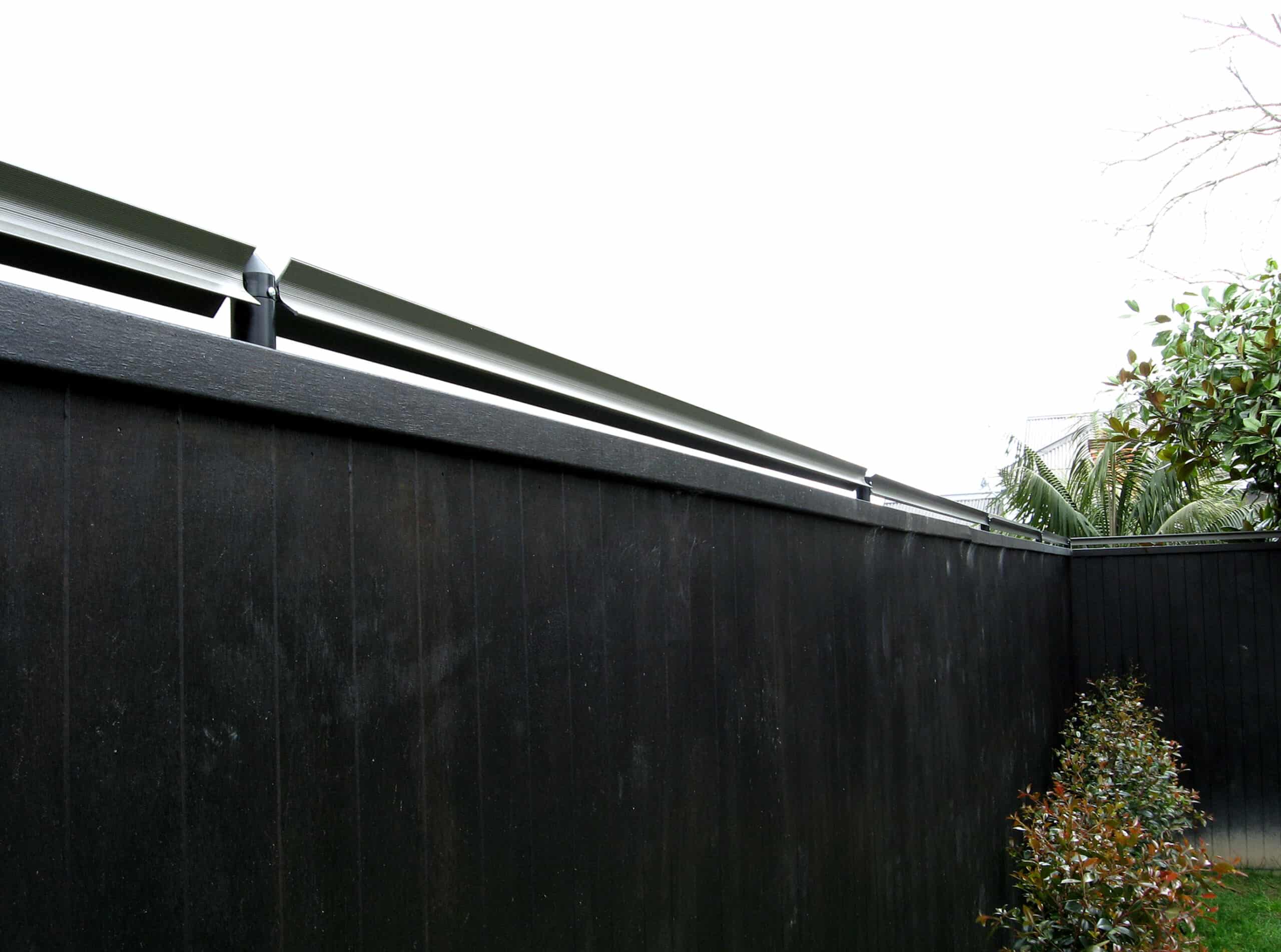 Oscillot cat fence system on top of timber fence