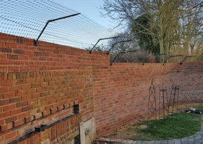 Purrfect Fence on a brick wall